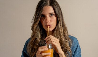 Young Woman Drinking Juice with a organic Straw - Close-Up Portrait