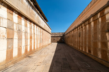 A stone corridor between striped walls at the ancient Jain temple in Shravanabelagola.