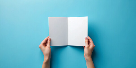 Hand holding blank brochure booklet or book mockup on blue background. Woman showing offset paper. Leaflet mock up holding hand. square Booklet template. A5 paper sheet display read first person