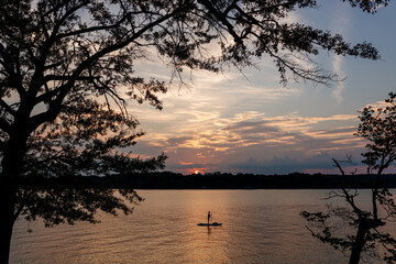 Beautiful sky and lake with boats, people relaxing on the shore at sunset. Beautiful orange and blue sky at dawn. Lake Bowen Anchor Park, Inman, SC, USA 