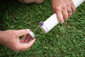 Male hands preparing a pipe with primer to fit together a PVC, polyvinyl chloride, line.