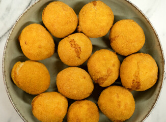 Top view of traditional arancini, fried fish croquettes in a bowl
