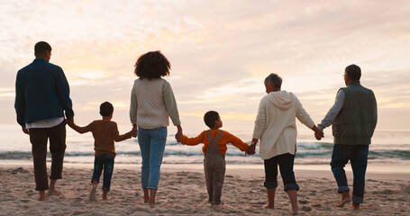 Family, holiday and holding hands at beach in summer for relax, travel and vacation as silhouette. People, children and back at ocean with solidarity for walking, trust and love together by sunset