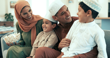 Muslim family, popcorn and watching tv on sofa in living room of home for bonding or comedy. Laughing, television or video with Islamic mother, father and kids in apartment for movie streaming