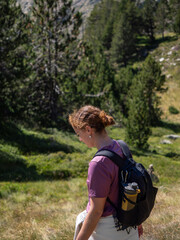 Naklejka premium Hiker with Backpack Walking Through Forested Mountain Area - Nature Exploration and Adventure