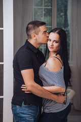 Naklejka premium Couple Embracing Near Window