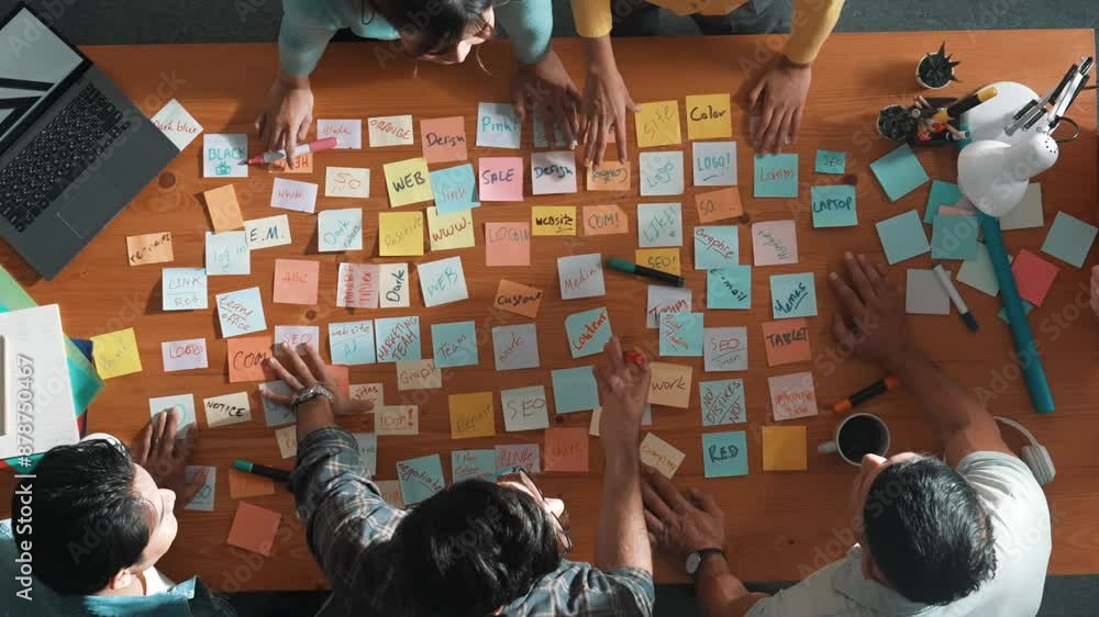 Poster top view of business team giving high five to celebrate project while standing at table with sticky 
