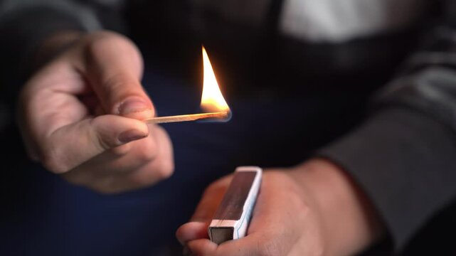 A young child strikes a match and lights it