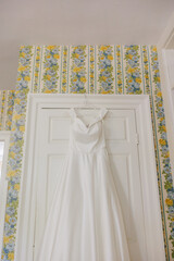 wedding dress hanging on hanger in house