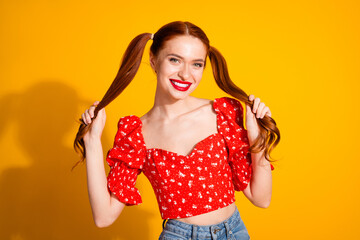 Photo portrait of attractive young woman pull hair tails dressed stylish red clothes isolated on yellow color background