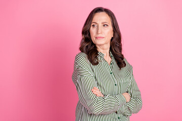 Fototapeta premium Photo of adorable lovely woman wear striped shirt arms crossed looking empty space isolated pink color background