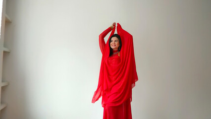 A dancer in a red suit is dancing with a red shawl an oriental dance on a white background. Free...