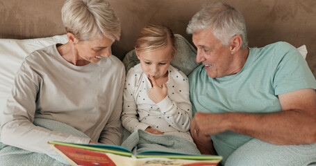 Grandparents, girl and reading book in bed for storytelling, literature and bonding at sleepover....