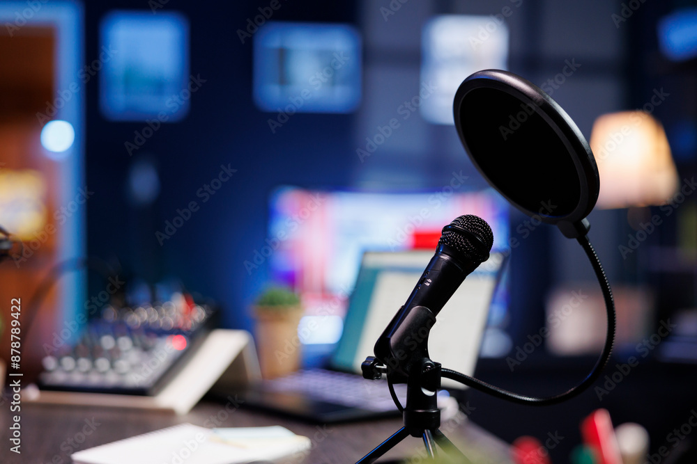 Poster closeup of a professional podcast microphone resting on a desk in a recording ready podcasting home 