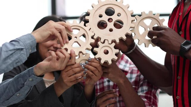 Office worker holding cog wheel as unity and teamwork in corporate workplace concept.