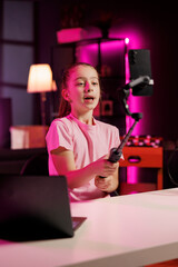 Girl using phone on selfie stick to film family vlog in home studio, talking about day at school. Kid recording content for online channel with cellphone camera, discussing with fans