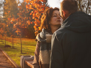 Fototapeta premium a man and a woman are about to kiss while walking in the park in autumn