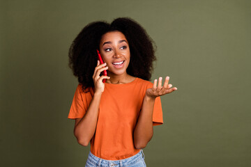 Fototapeta premium Photo of shiny attractive lady dressed orange outfit talking modern device looking empty space isolated khaki color background