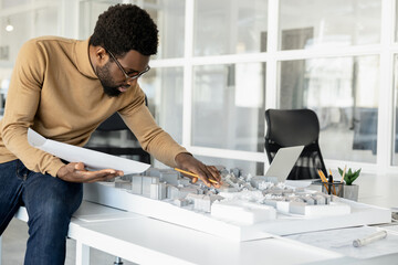Successful man architect reviewing blueprints in his workplace