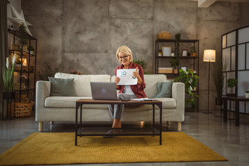 Obraz premium Mature senior woman work from home have consultation via video call