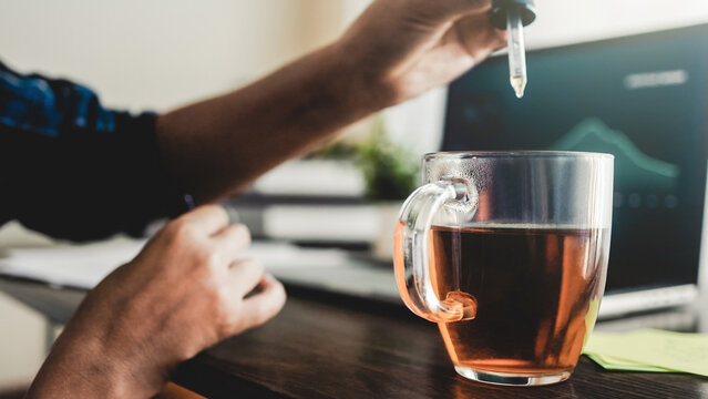 Cbd oil. Business woman taking in drink for anxiety and stress treatment at work office. Alternative medicine