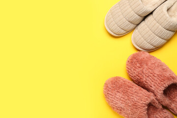 Two pairs of soft slippers on yellow background. Top view