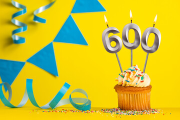 Birthday candle number 600 with cupcake - Yellow background with blue pennants