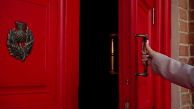 Woman opening a red door