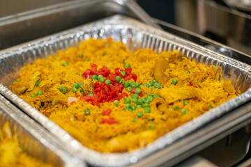 Yellow rice in a silver pan, rice catering at an event in a serving container. 