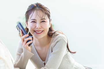 リビングでスマートフォンを使う女性のポートレート