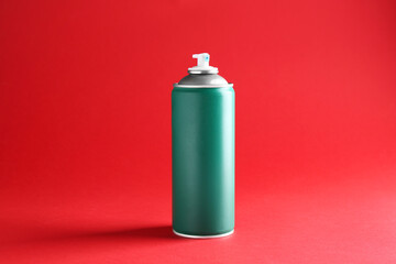 One green spray paint can on red background
