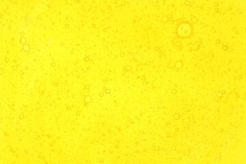 Bright yellow liquid as background, top view