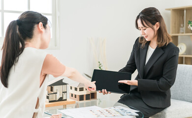 クレーム対応で謝罪する不動産・ハウスメーカーのビジネスウーマン
