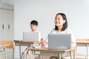 パソコンを使って勉強する日本人の子供（ICT教育・授業・生徒・笑顔）
