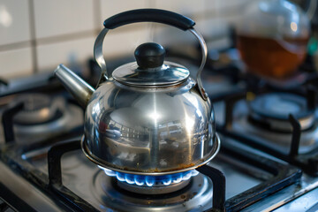 Boiling Kettle on Gas Stove with Blue Flame Creating a Warm Kitchen Atmosphere and Heating Water for Cooking