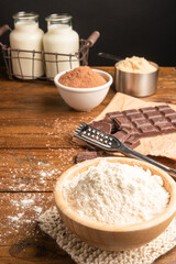 Products and objects for baking chocolate cake on dark wooden table. Concept of home baking.