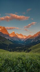 A stunning sunset over a mountain landscape with lush grass and trees
