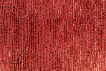 Red piece of textured cloth with abstract pattern.