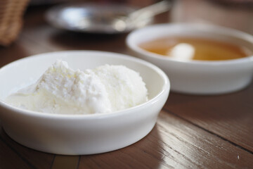 butter cream and honey in a bowl on table .