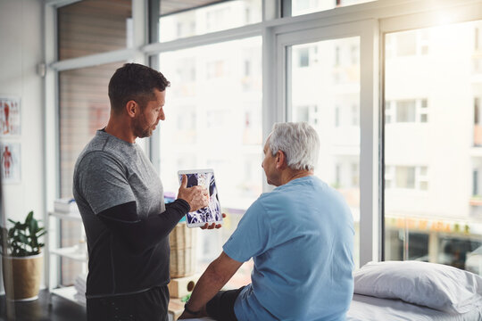 Elderly, man and tablet in physio with Xray consultation for joint injury, healing and treatment planning. Rehab, senior person and chiropractor with digital technology for patient muscle health