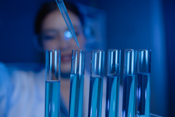 scientist is working on an important liquid inside tube in laboratory, the discovery of a vaccine to protect against currently spreading virus has been discovered, wear gloves and goggles for safety