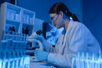 scientist is using microscope in laboratory, chemical researcher works in chemistry with...