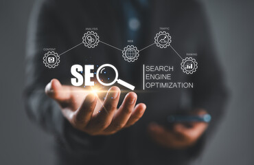 Businessman hold virtual SEO icon to analyze SEO search engine optimization for promoting ranking...