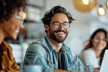 Obraz premium Smiling businessman in casual attire working on laptop during office meeting