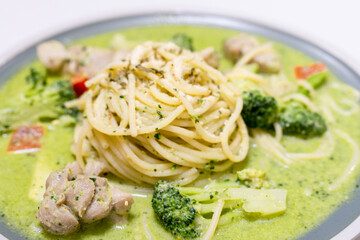 delicious pesto pasta, featuring a rich, green basil pesto sauce. The dish is beautifully presented with fresh ingredients, offering a flavorful and savory experience