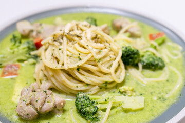 delicious pesto pasta, featuring a rich, green basil pesto sauce. The dish is beautifully presented with fresh ingredients, offering a flavorful and savory experience