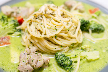 delicious pesto pasta, featuring a rich, green basil pesto sauce. The dish is beautifully presented with fresh ingredients, offering a flavorful and savory experience