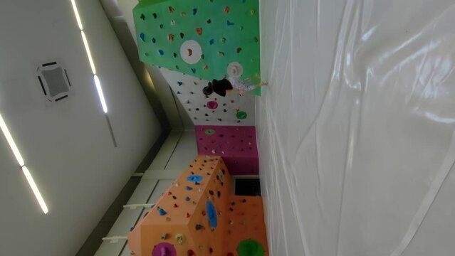 Putrajaya, Malaysia - December 1, 2023 A little girl practicing summersault at the rock climbing area. 4K Vertical