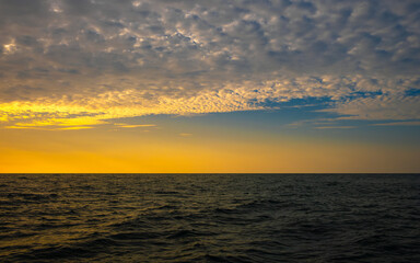 Fototapeta premium Panoramic views of the skyline The sun sets in the evening sky with colorful clouds. and beautiful cloud patterns In the soft light of the evening at sea