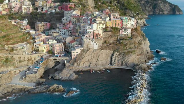 Aerial view of Manarola village on sunny evening. The second-smallest of the famous Cinque Terre charming and romantic towns. Italian Riviera coastline bird's eye view, Liguria, Northern Italy.